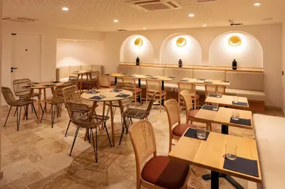 a restaurant with tables and chairs in a room at Hôtel Escaletto in Aix-en-Provence