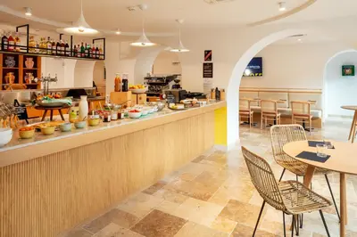 a restaurant with a counter and tables and chairs at Hôtel Escaletto in Aix-en-Provence