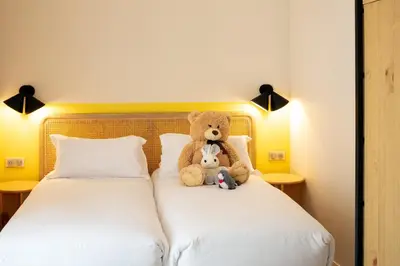 a teddy bear sitting on top of a bed at Hôtel Escaletto in Aix-en-Provence