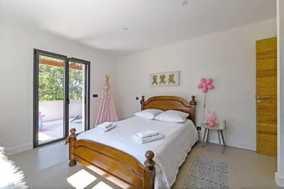 a bedroom with a bed with white sheets and a window at Villa de prestige 10 personnes à Eyragues in Eyragues