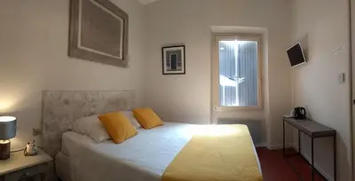 a bedroom with a bed with yellow pillows and a window at Mas de Camejean in Lambesc