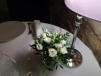 a vase of white flowers on a table at Hostellerie Le Roy Soleil in Ménerbes