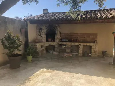 an outdoor patio with a table and a fireplace at Villa dans le LUBERON à 2 km de LOURMARIN in Lauris