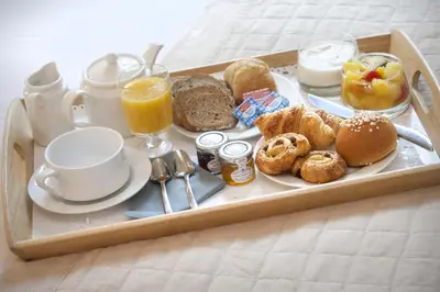 a tray of breakfast food on a bed at Hôtel de France in Aix-en-Provence