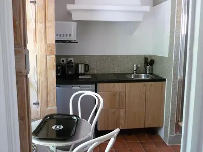 a small kitchen with a sink and a table and chairs at Appartement Cours Mirabeau CrsMb in Aix-en-Provence