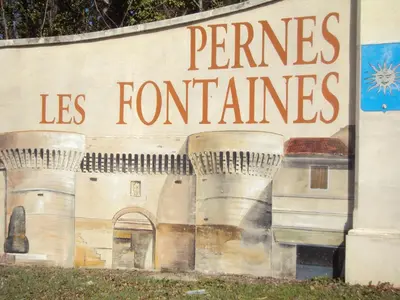 a sign on the side of a building that reads pennines leumes at Maison d'Hôtes La Douloire in Pernes-les-Fontaines