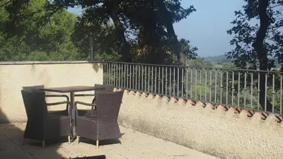 a table and two chairs sitting next to a fence at Mas du Kairos in Venasque