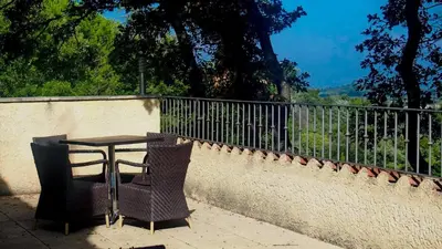 a table and two chairs sitting next to a fence at Mas du Kairos in Venasque