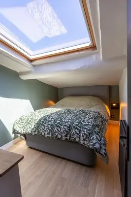a bed in a small room with a skylight at DUPLEX MIRABEAU - Roof terrace with panoramic view in Aix-en-Provence