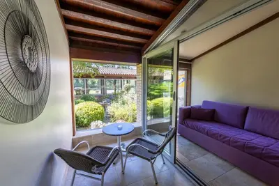 a living room with a purple couch and chairs at Vacances Bleues Hôtel Castel Luberon in Apt