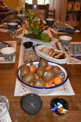 a table with a bowl of fruit and bread on it at Villa Lumières in Goult