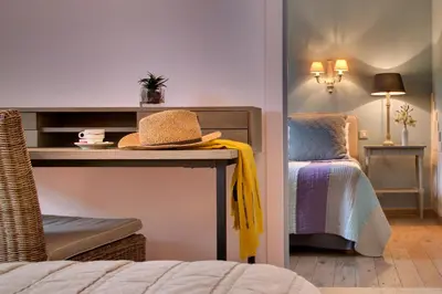a room with a bed and a hat on a table at Hôtel Le Pré Saint Michel in Manosque