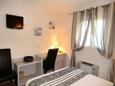 a bedroom with a bed and a desk and a television at Hôtel du Parc, Avignon Est, The Originals City, in Entraigues-sur-la-Sorgue