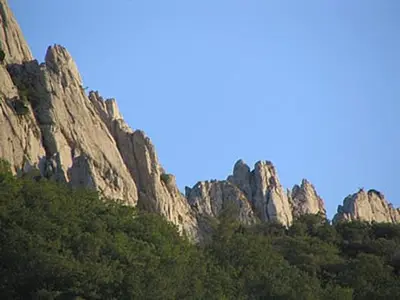 a rocky mountain with trees in front of it at Hôtel du Parc, Avignon Est, The Originals City, in Entraigues-sur-la-Sorgue