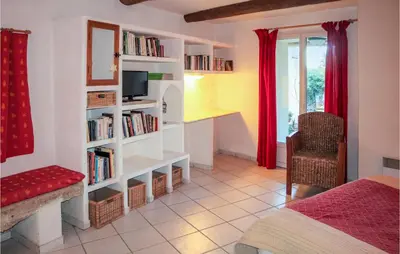 a bedroom with a bed and a book shelf with books at Cozy Apartment In Villes Sur Auzon in Villes-sur-Auzon