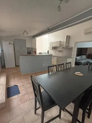 a kitchen and dining room with a black table and chairs at Maison de campagne in Lançon-Provence