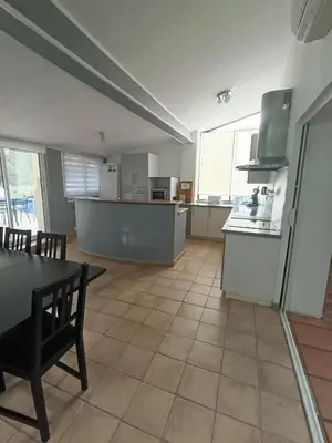a large kitchen with a table and a counter top at Maison de campagne in Lançon-Provence