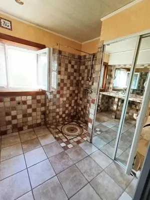 a bathroom with a shower and a tiled floor at Maison de campagne in Lançon-Provence