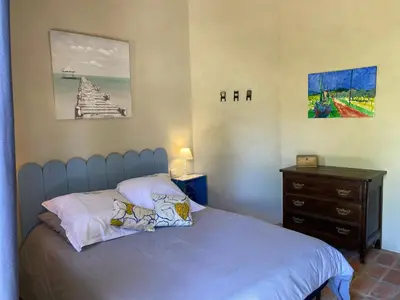 a bedroom with a bed and a wooden dresser at Gite des amis Domaine de Mas Caron in Caromb