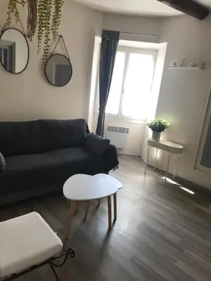 a living room with a couch and a table at Au cœur de Céreste in Céreste
