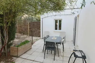 a patio with a table and chairs in a garden at Le mas Sainte Marie in Venasque