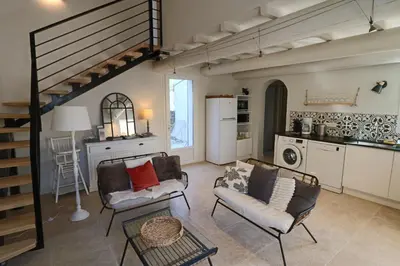 a living room with two chairs and a table at Le mas Sainte Marie in Venasque