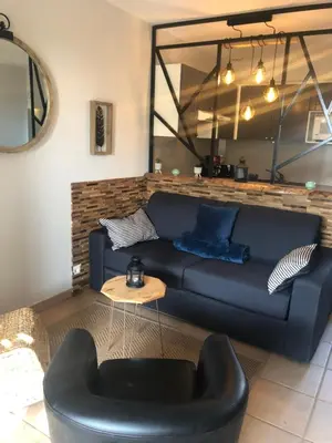 a living room with a blue couch and a table at Le Bastidon de L Olivier in Gordes