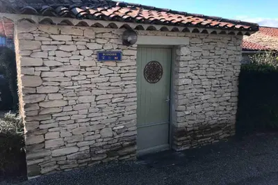 a stone building with a door and a stone wall at Le Bastidon de L Olivier in Gordes