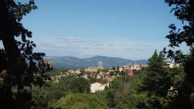 a view of a town from a hill with trees at Mas du Kairos - Gite Romarin in Venasque