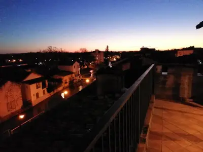 a view of a city at night from a balcony at LE BELVEDERE in LʼIsle-sur-la-Sorgue