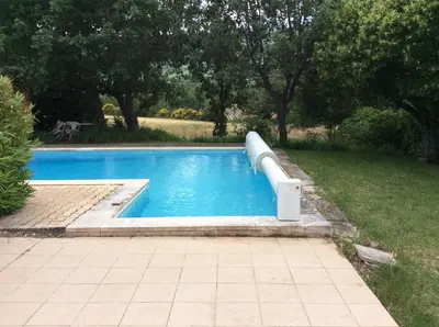 a pool with a water slide in a yard at Villa piscine face au grand luberon Cereste in Céreste