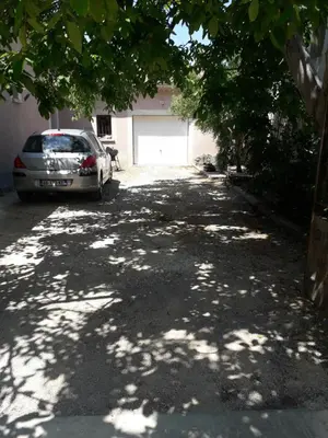 a driveway with a car parked next to a garage at Gite le bagnol un coin de paradis in Maubec