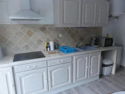 a kitchen with white cabinets and a sink at Gite le bagnol un coin de paradis in Maubec
