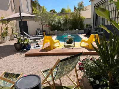 a patio with chairs and a pool with a table at Cosy Studio en Provence in Carpentras