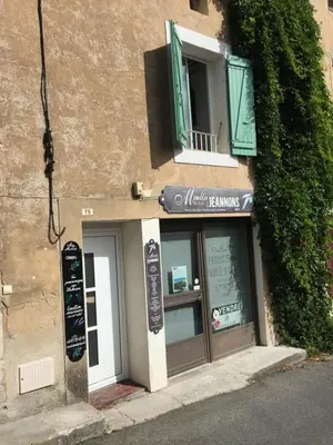 a restaurant with a window and a sign on a building at Chez Marius Gordes Vue panoramique sur luberon in Gordes