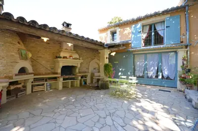 a courtyard of a house with a fireplace at Maison Le Thor avec piscine part. in Le Thor