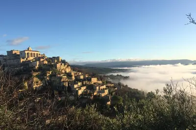 a village on top of a hill with a sea of clouds at La Forge - Gordes in Gordes