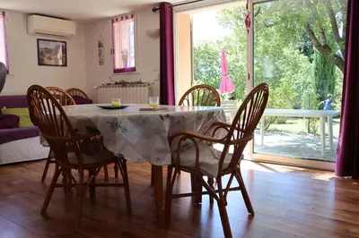 a dining room with a table and chairs and a window at IA ORANA in Gargas
