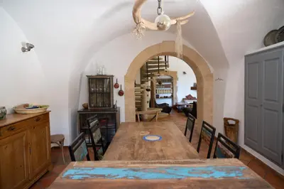 a dining room with a wooden table and chairs at Une Chambre en Luberon in Puyvert
