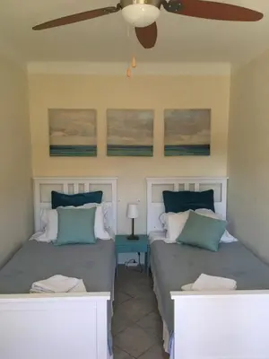 two beds in a room with a ceiling fan at The Willow Tree in Le Thor