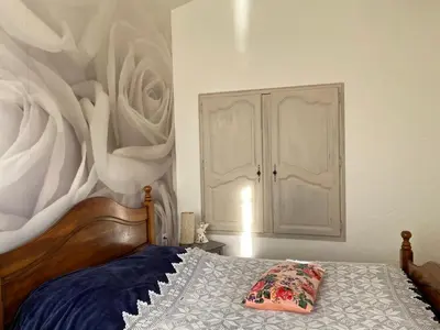 a bedroom with a bed with a painting on the wall at Maison de famille au coeur du Luberon in Mérindol