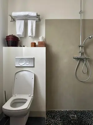 a bathroom with a toilet and a shower with towels at La Cour Carrée in Rustrel