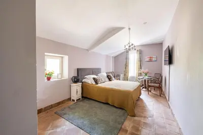 a bedroom with a bed and a table at La Pastorale in Lagnes