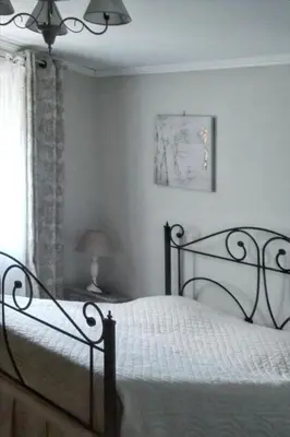 a bedroom with a bed with white sheets and a window at Charmante villa à Dauphin avec piscine privée et jardin in Dauphin