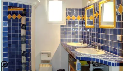 a blue tiled bathroom with two sinks and two mirrors at Villa charmante à Dauphin avec piscine privée in Dauphin