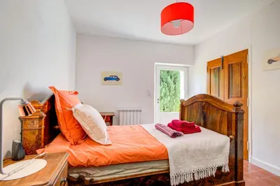 a bedroom with an orange bed and a desk at Les Chambres du Perussier in Cucuron