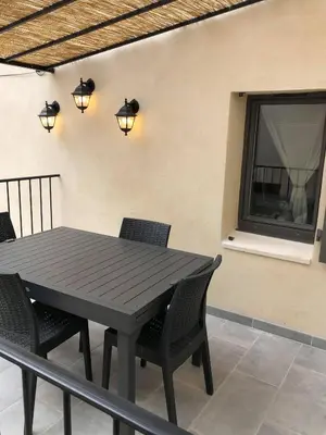 a black table and chairs on a balcony with a window at Provence Luberon Bonnieux location gite chez Marcelle in Bonnieux