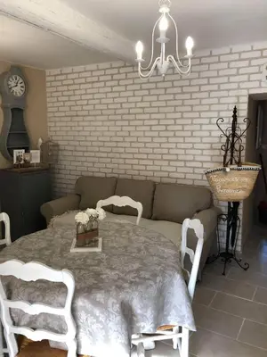 a room with a table and chairs and a brick wall at Provence Luberon Bonnieux location gite chez Marcelle in Bonnieux