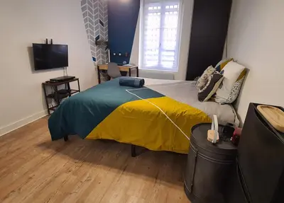 a bedroom with a bed with a yellow and blue blanket at Studio Bon pasteur hyper centre Aix in Aix-en-Provence
