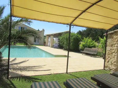 a yellow umbrella in front of a swimming pool at Maison provençal avec PISCINE in Cavaillon